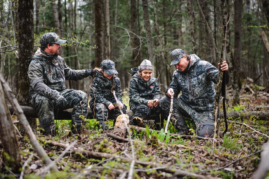 Un groupe de personnes dans la foret portant des habits camouflage
