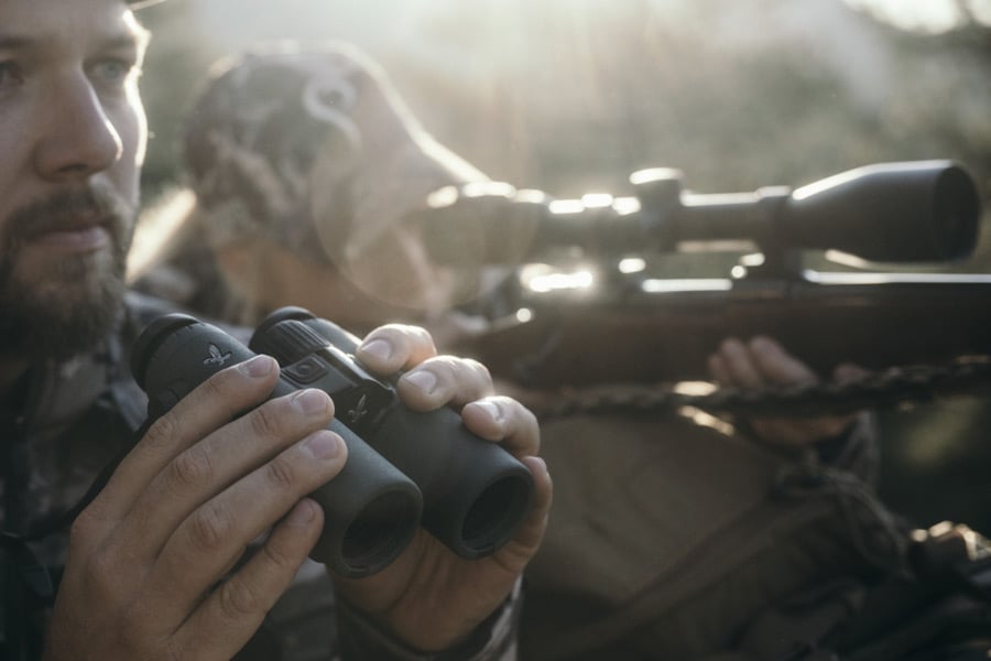 Chasseurs avec jumelles et lunette de visée à l'arrière